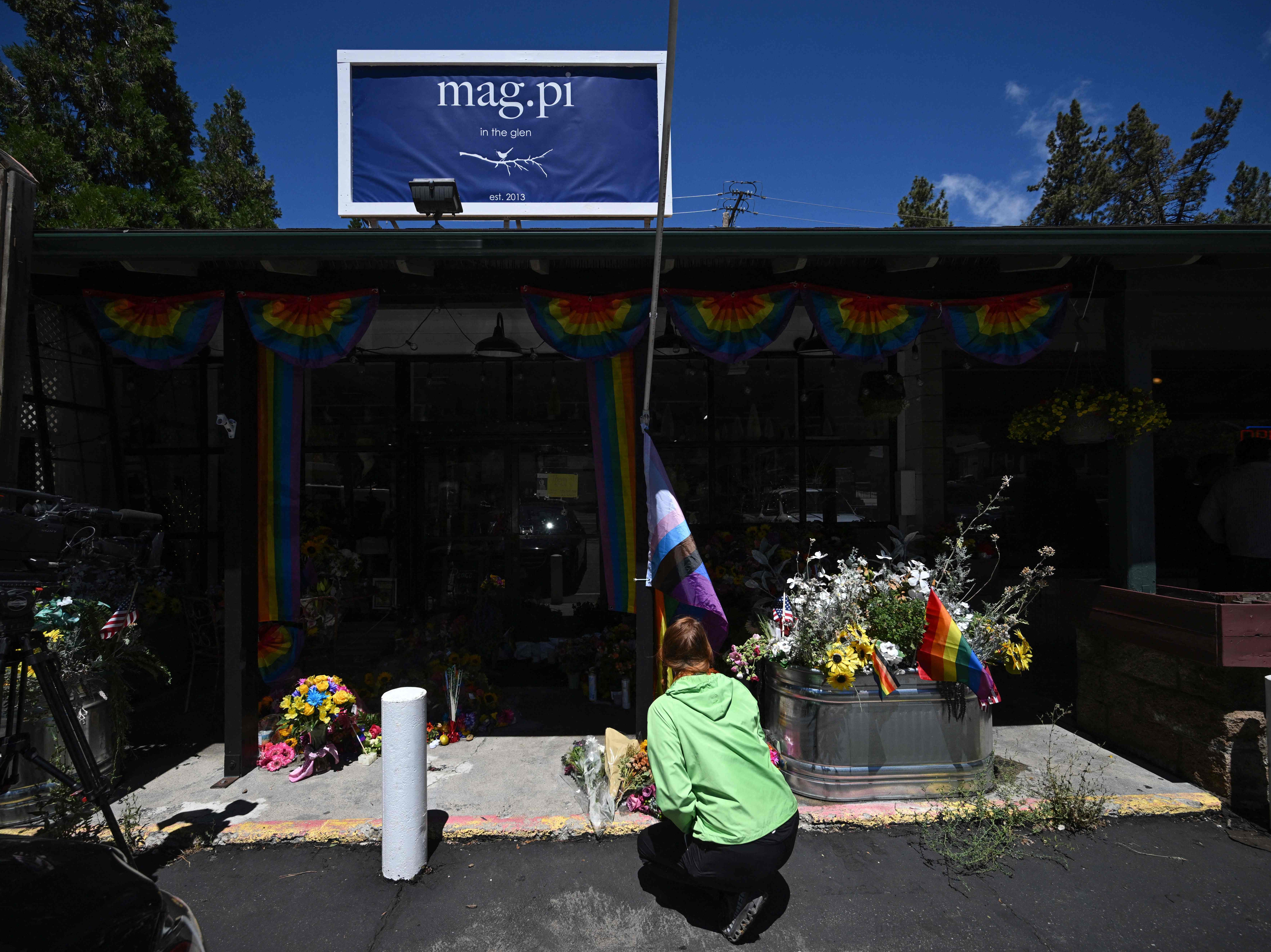 A resident leaves flowers at a makeshift memorial outside the Mag.Pi clothing store