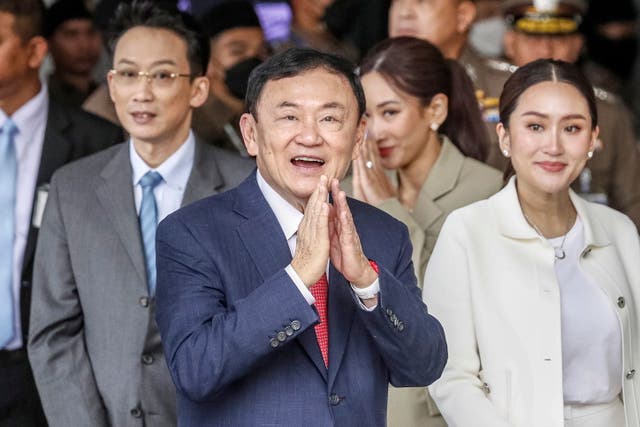 <p>Former Thai prime minister Thaksin Shinawatra (C), accompanied by his daughter and Pheu Thai Party prime ministerial candidate Paetongtarn Shinawatra and his son Panthongtae Shinawatra, greets supporters and journalists upon his arrival at Don Mueang airport in Bangkok, Thailand</p>