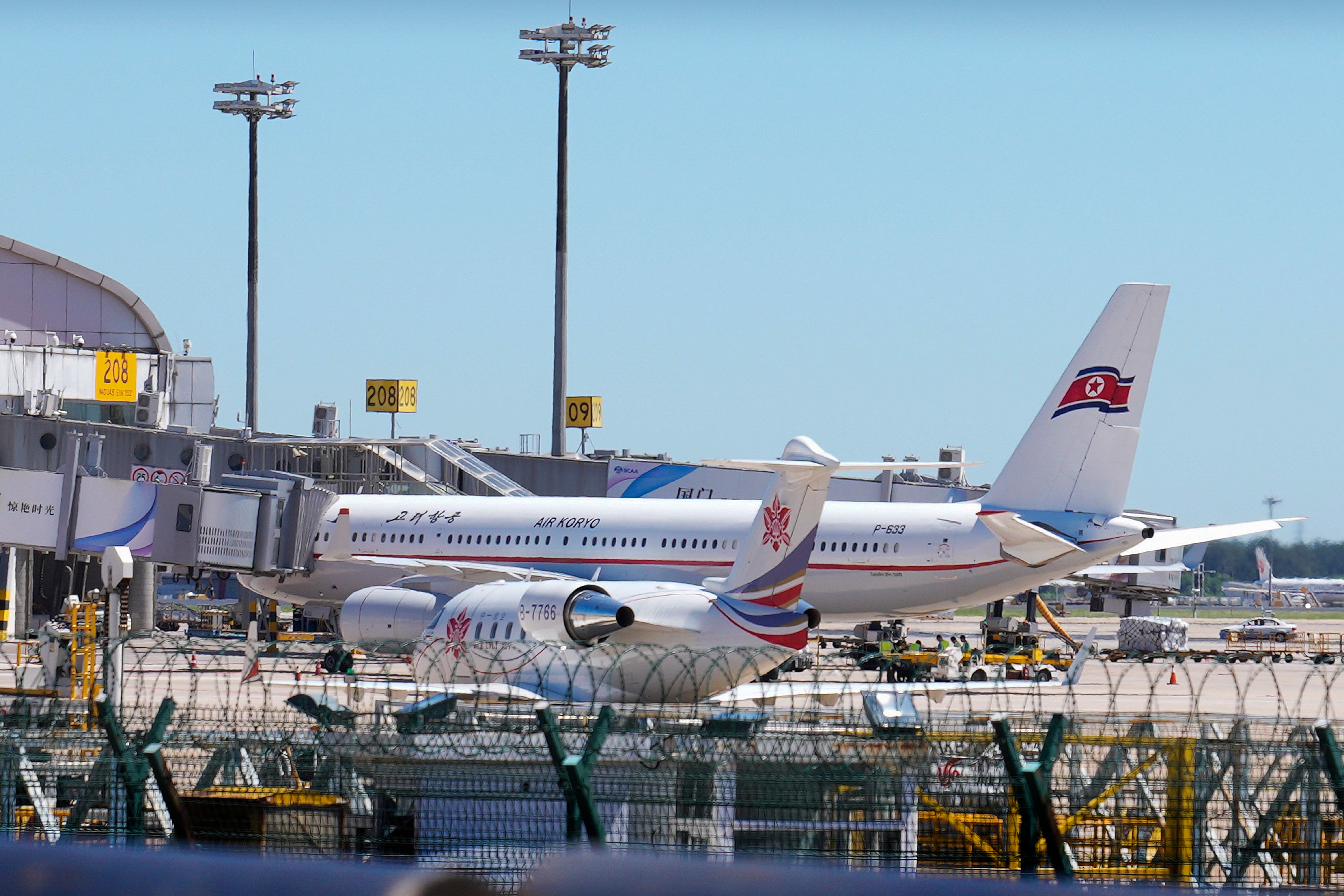 <p>Ground crew work near an Air Koryo commercial plane on the tarmac at the Beijing Capital International Airport in Beijing on 22 August</p>