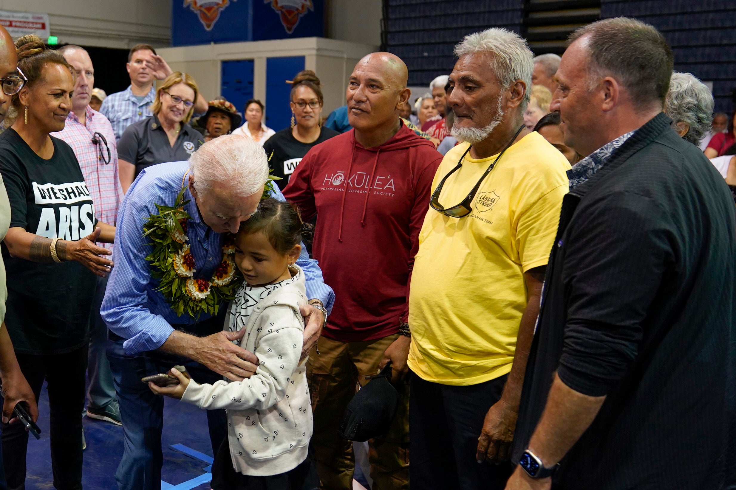President Joe Biden hugs a child as he meets with community members impacted by the Maui wildfires at Lahaina Civic Center,