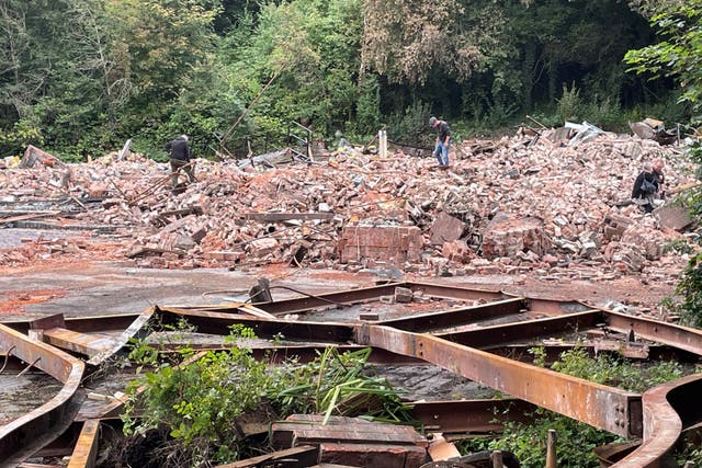 People inspect the rubble remains of The Crooked House pub in Himley, near Dudley in the West Midlands (Matthew Cooper/PA)