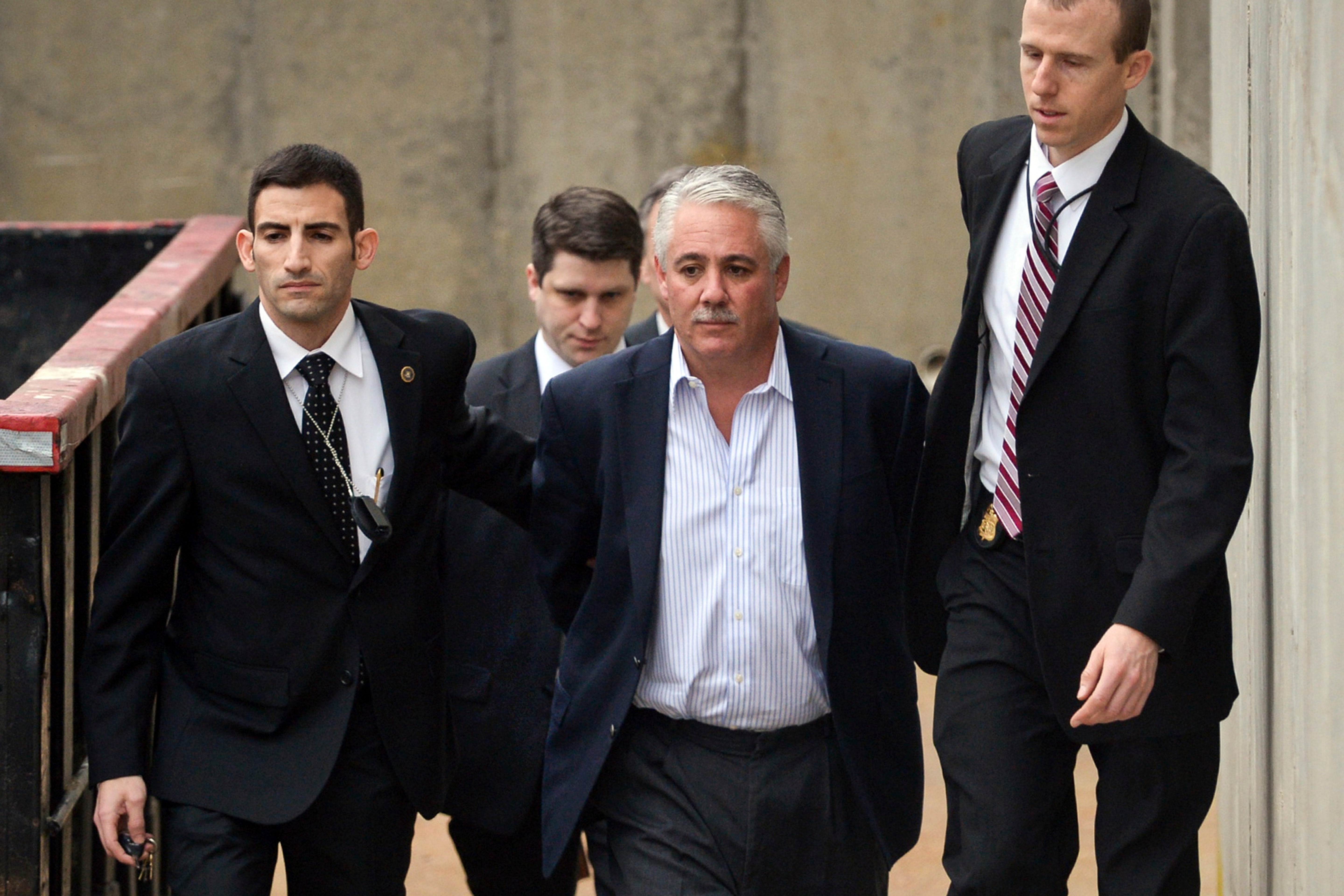 Former Suffolk County Police Chief James Burke, second from right, is escorted to a vehicle by FBI personnel after his arrest in 2015