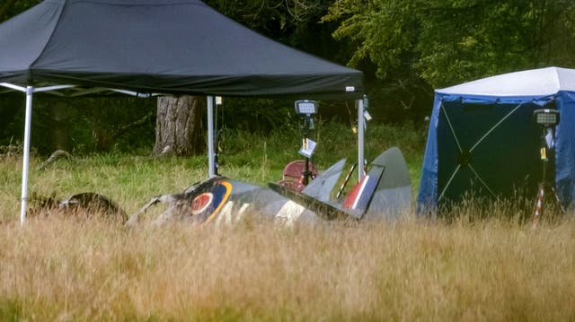 <p>Police and emergency responders at the scene of an aircraft crash in a field near Enstoe</p>