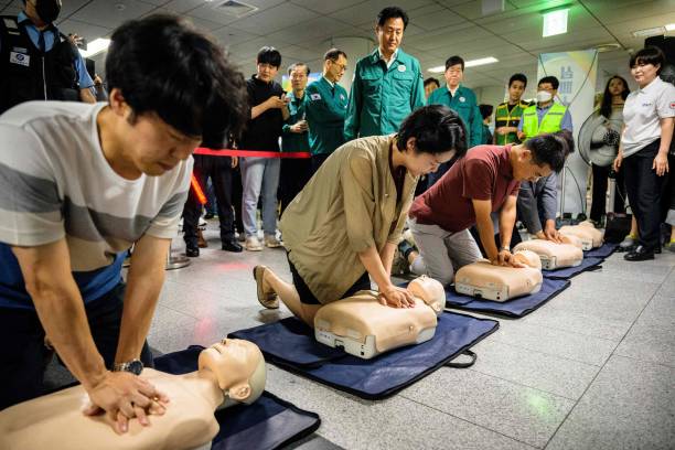 Seoul Mayor Oh Se-hoon (top centre) watches as people receive CPR training while practicing on dummys during a civil defence drill against possible artillery attacks by North Korea, in a subway station in Seoul on 23 August 2023