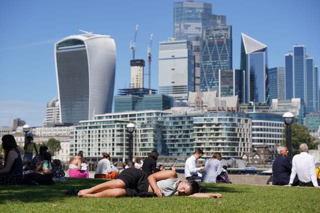 People enjoy the warm weather in Potters Fields Park in London (Lucy North/PA)