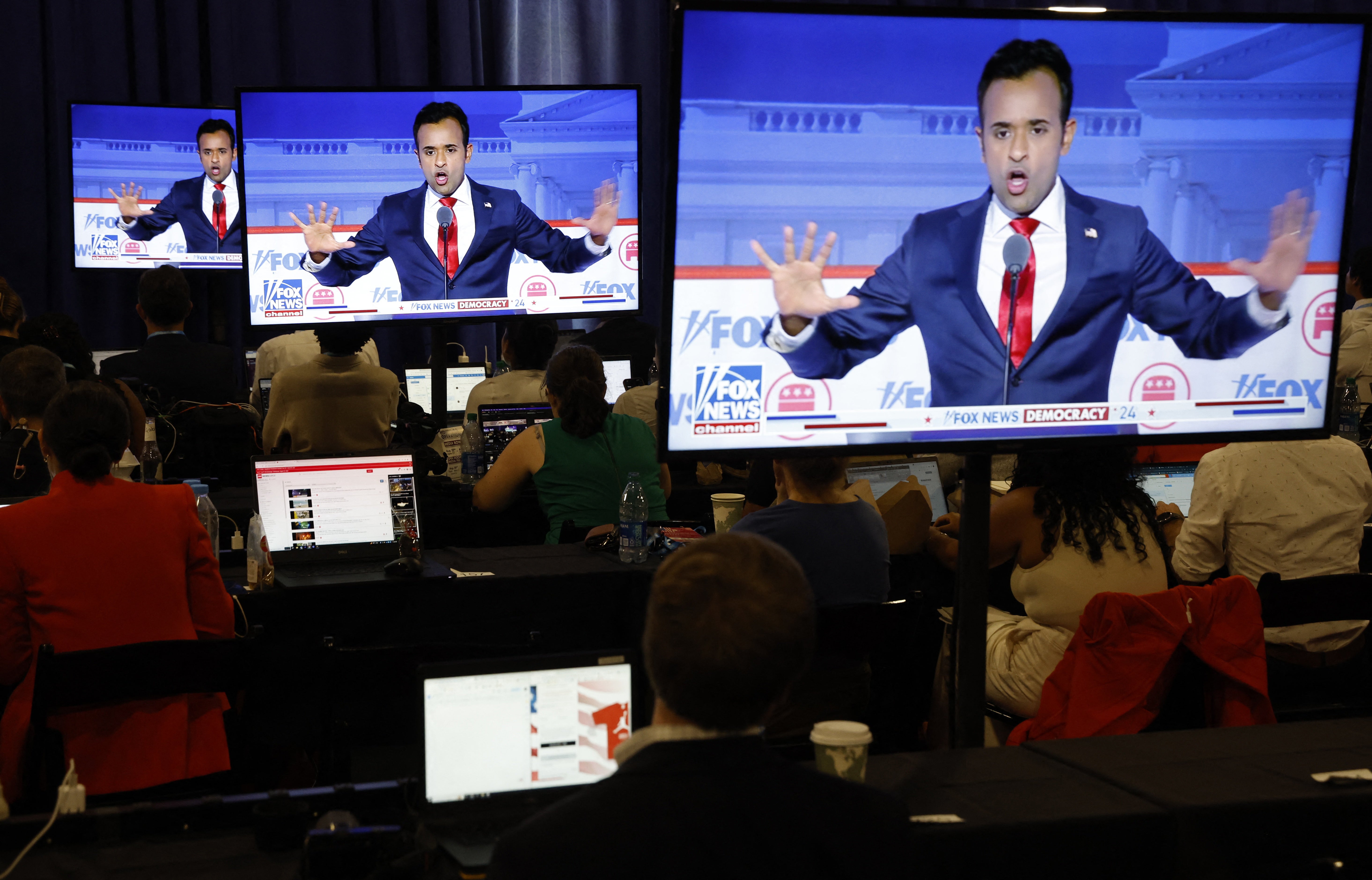 Former biotech executive Vivek Ramaswamy is seen debating on screens in the media filing center at the first Republican candidates' debate of the 2024 U.S. presidential campaign in Milwaukee, Wisconsin