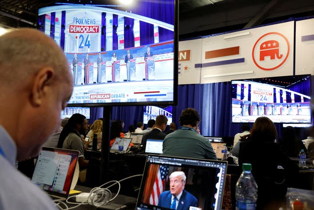 <p>A reporter watches former President Donald Trump's online interview with Tucker Carlson in the media filing center during the first Republican candidates' debate of the 2024 U.S. presidential campaign in Milwaukee, Wisconsin, U.S. August 23, 2023</p>