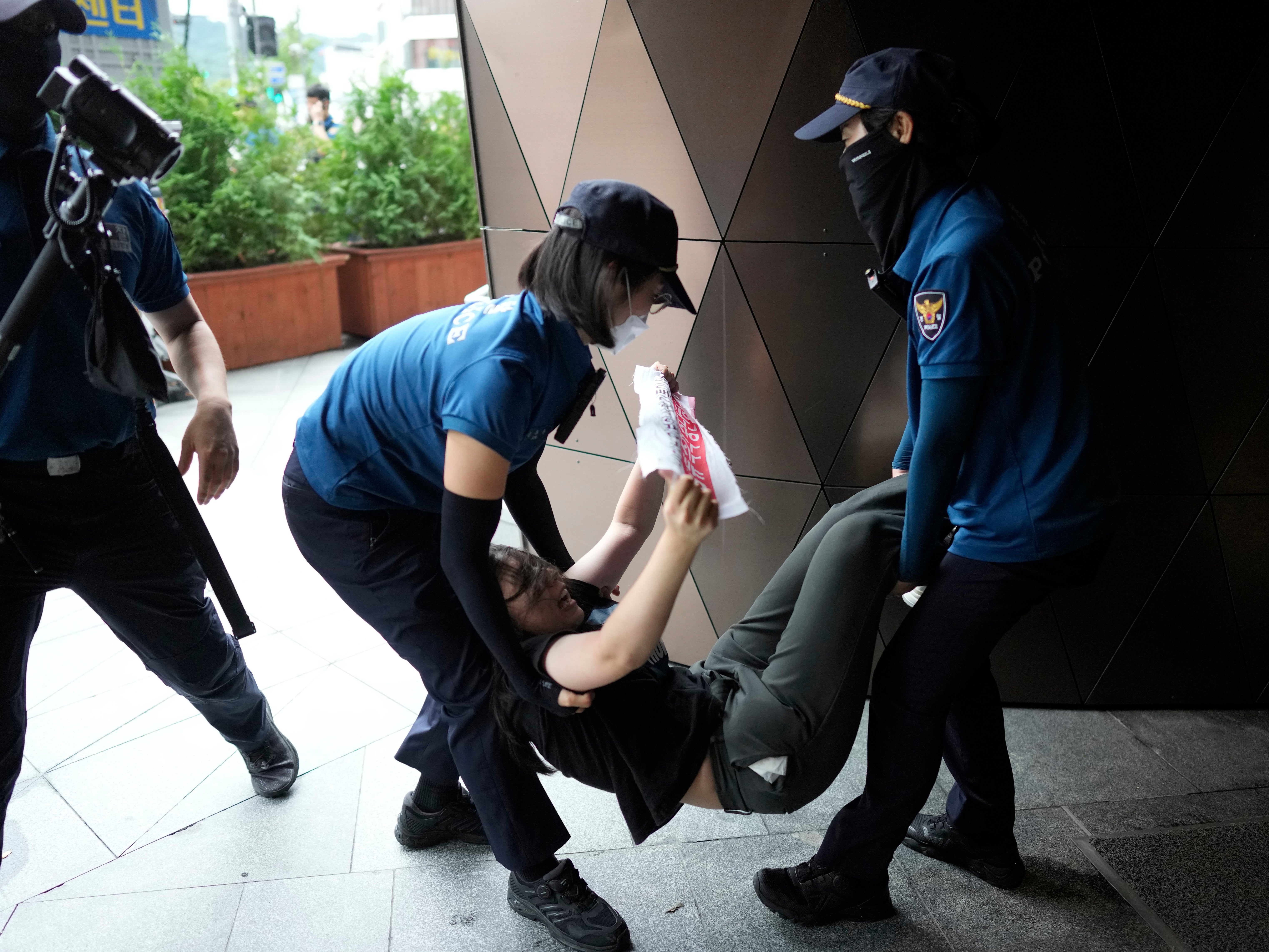 A protester is carried out of the Japanese embassy in Seoul