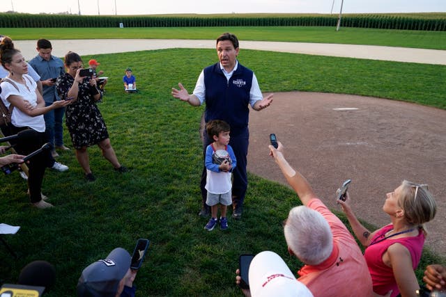 <p>Ron DeSantis speaks to reporters at Iowa’s famous ‘Field of Dreams’ baseball pitch on 24 August </p>