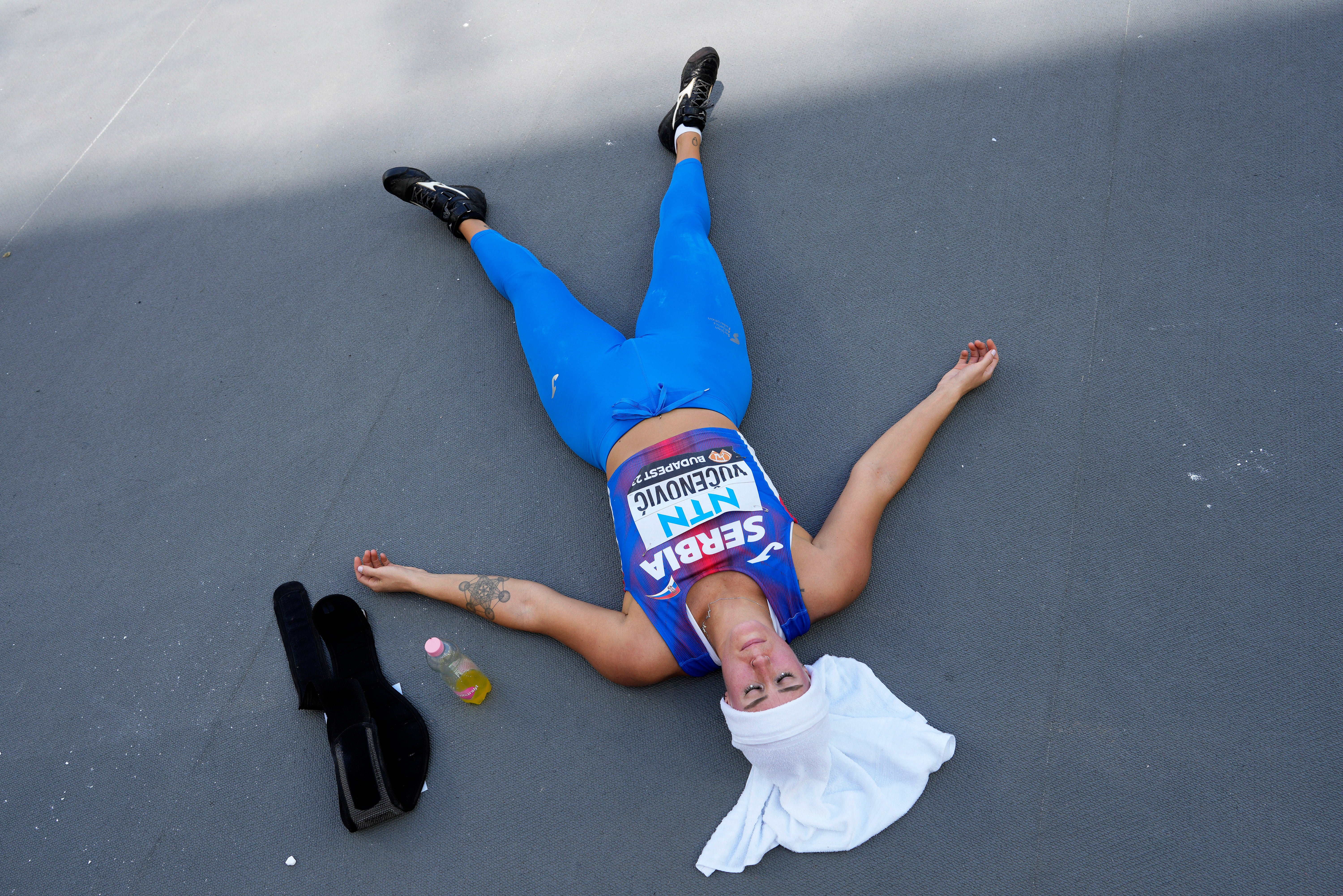 Marija Vucenovic, an Olympic athlete from Serbia, rests in the shade between attempts in the Women’s javelin throw qualification during the World Athletics Championships last month