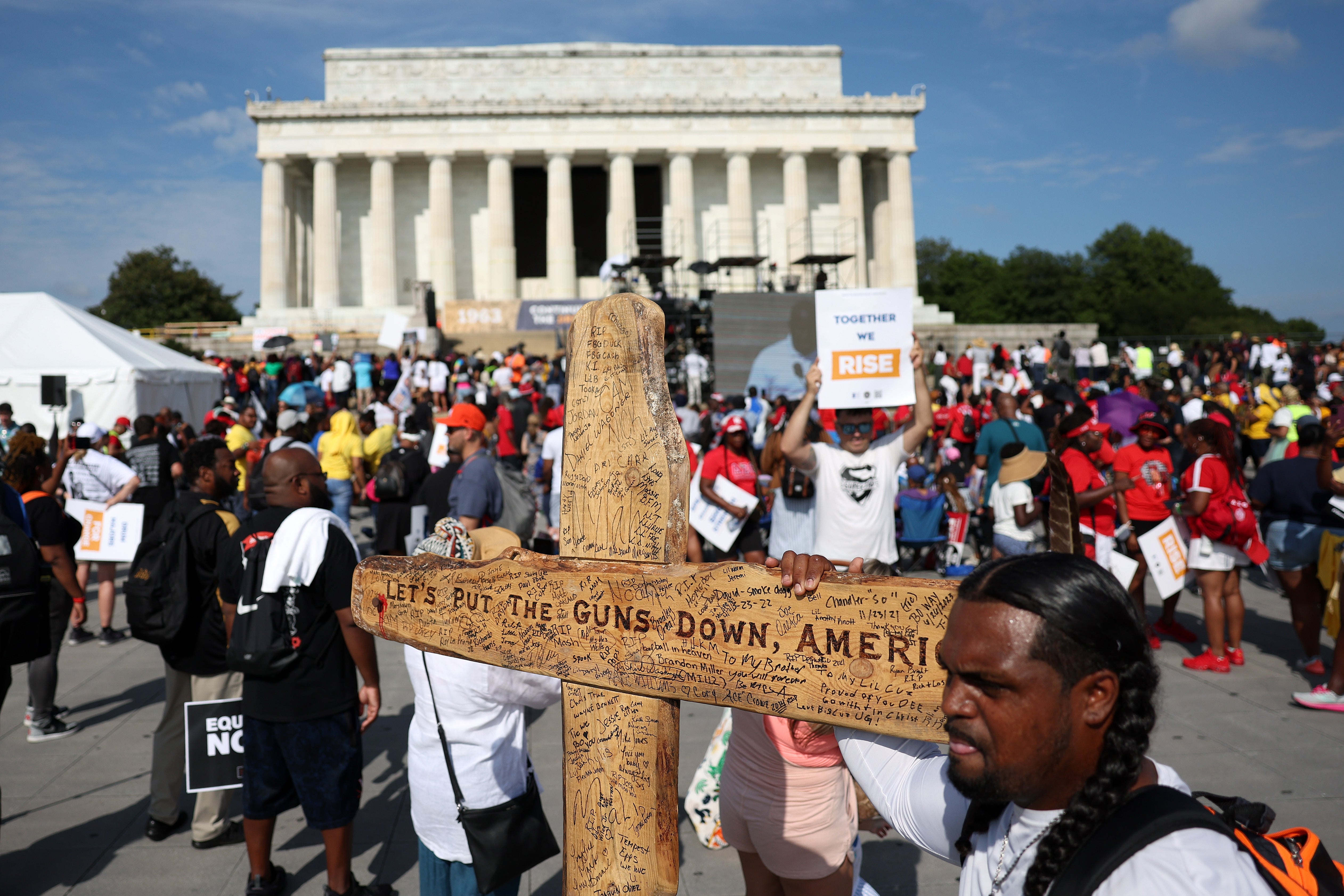 Civil rights supporter Denorver Garrett carries a cross as he attends the 60th Anniversary Of The March On Washington at the Lincoln Memorial on August 26, 2023 in Washington, DC