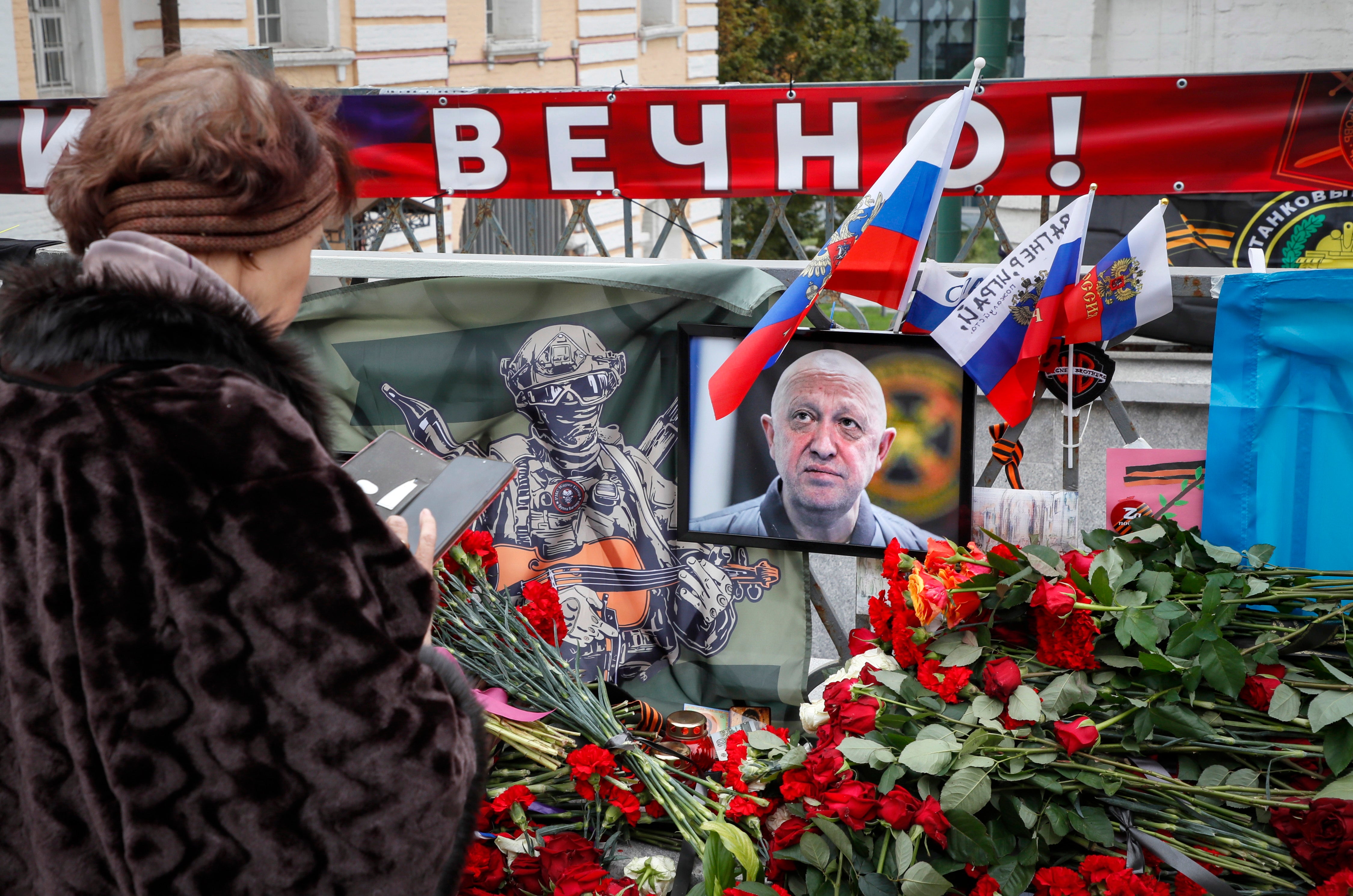 A woman stands in front of an informal memorial to PMC Wagner chief Yevgeny Prigozhin in Moscow