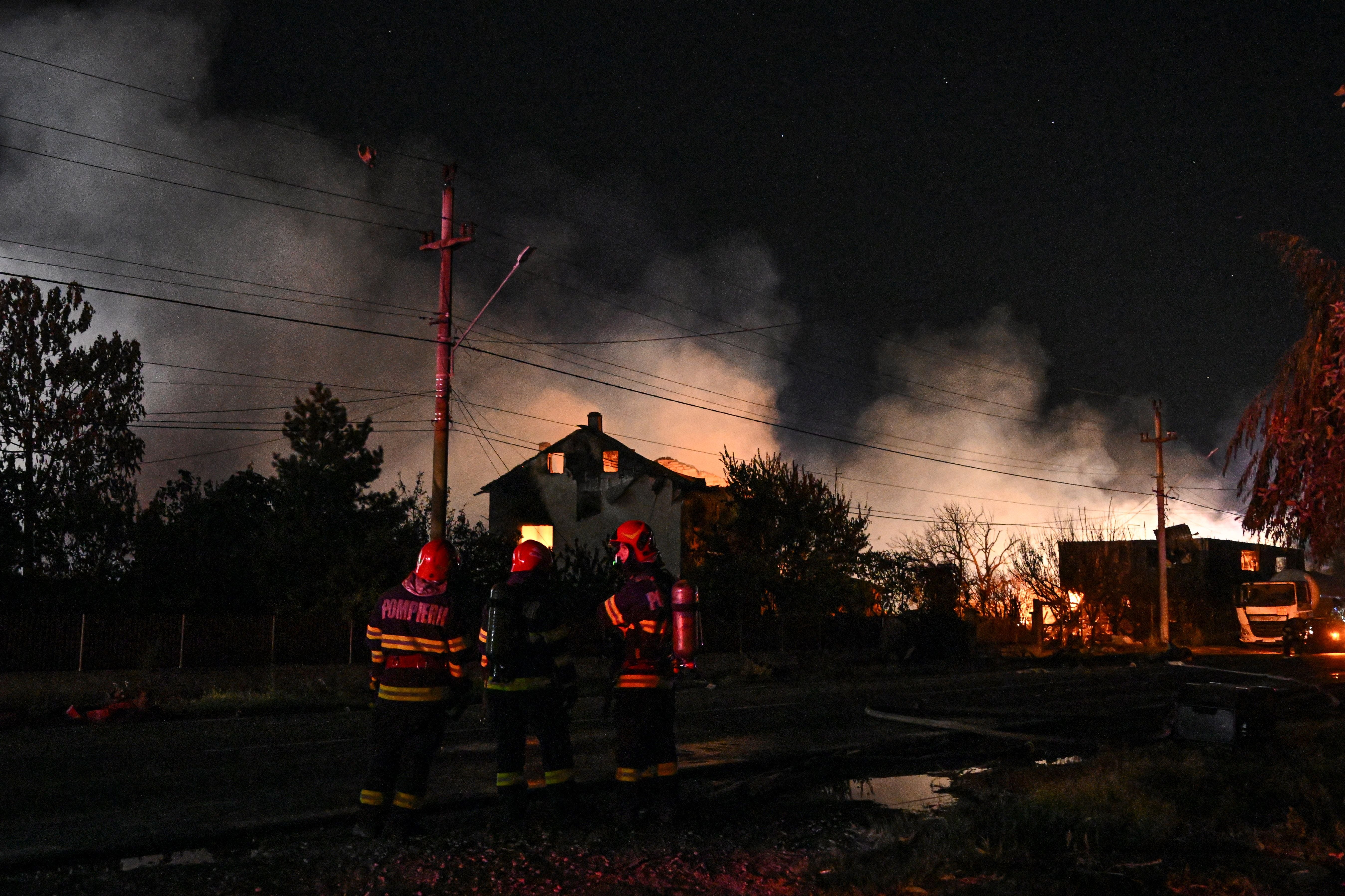 Romanian firemen work on the scene of a fire during an intervention in Crevedia village