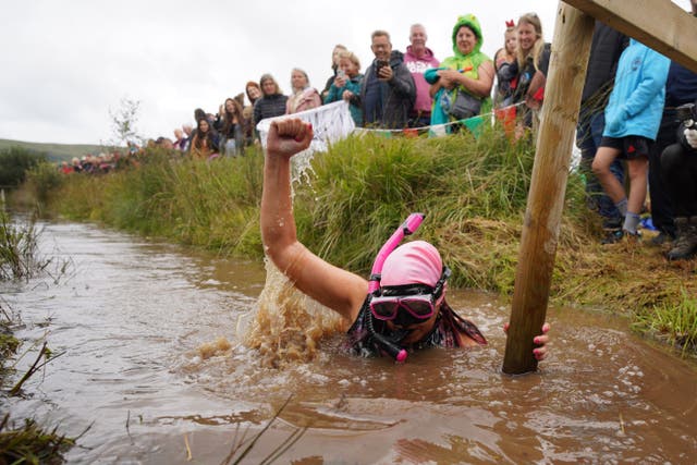 Competitors take part in the Rude Health World Bog Snorkelling Championships at Waen Rhydd peat bog in Llanwrtyd Wells (Ben Birchall/PA)