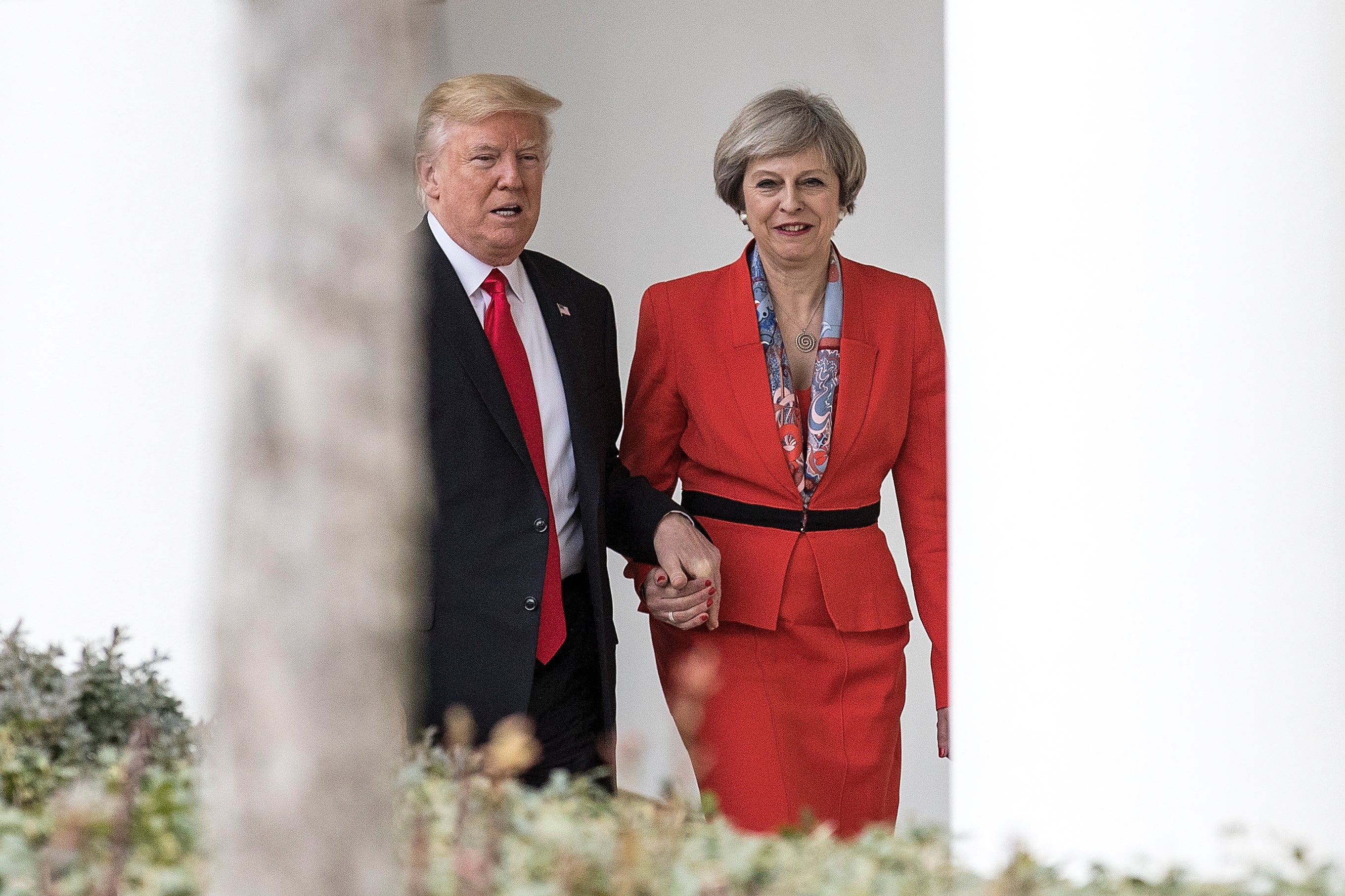 Former Prime Minister Theresa May and former U.S. President Donald Trump walk along The Colonnade of the West Wing at The White House on January 27, 2017