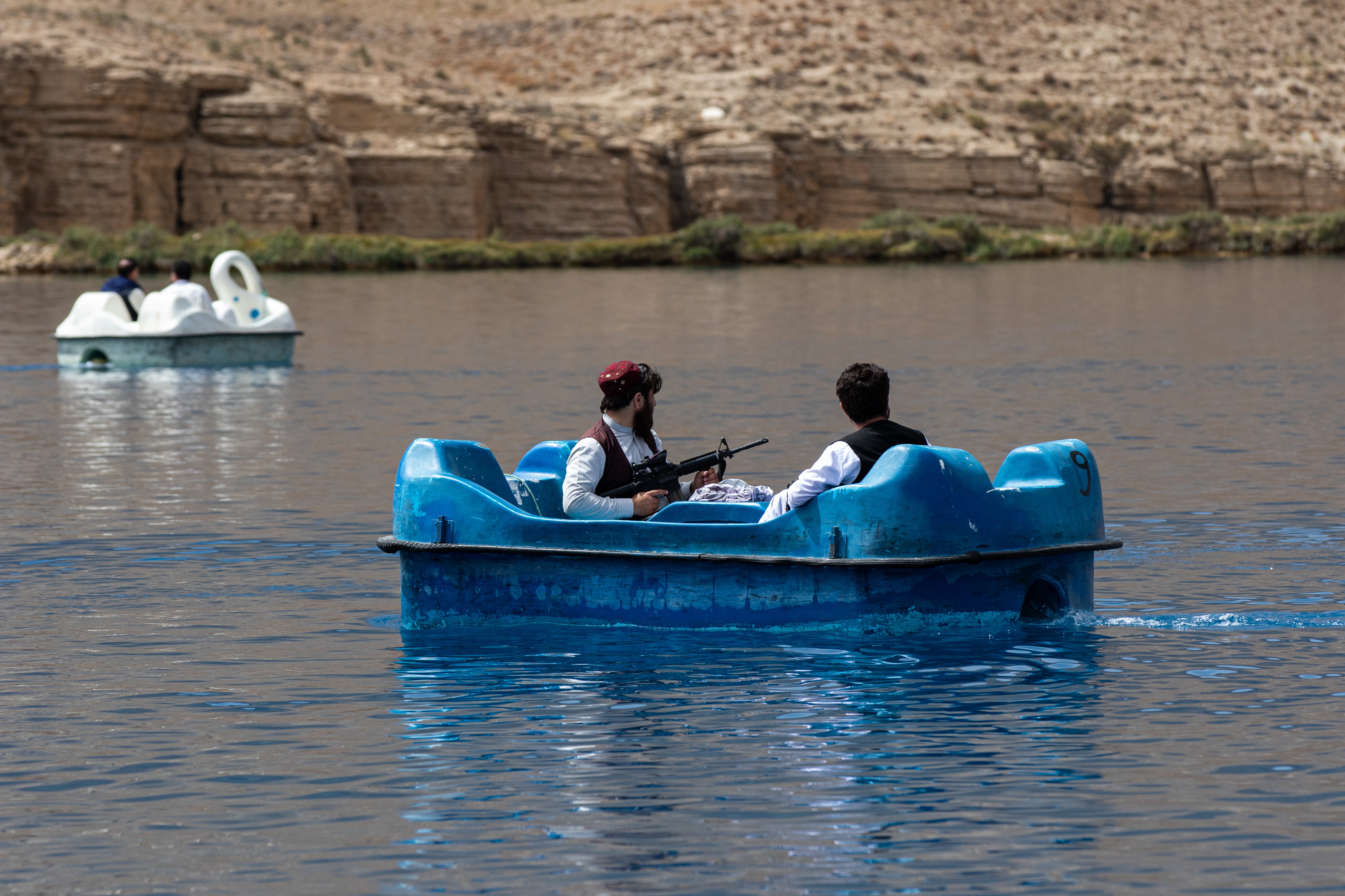 Taliban members paddle in a boat in Band-e-Amir
