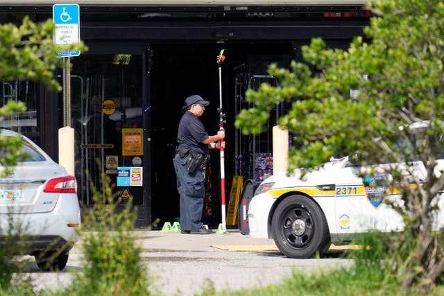 <p>Law enforcement officers take measurements in front of a Dollar General store, Sunday, 27 August 2023, in Jacksonville, Fla., at the scene of a mass shooting a day earlier </p>