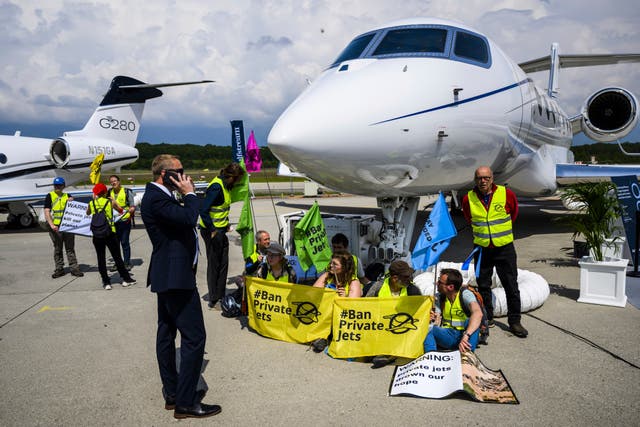 <p>Environmental activists handcuff themselves to private jets at the Geneve Aeroport in Geneva, Switzerland in May 2023 </p>