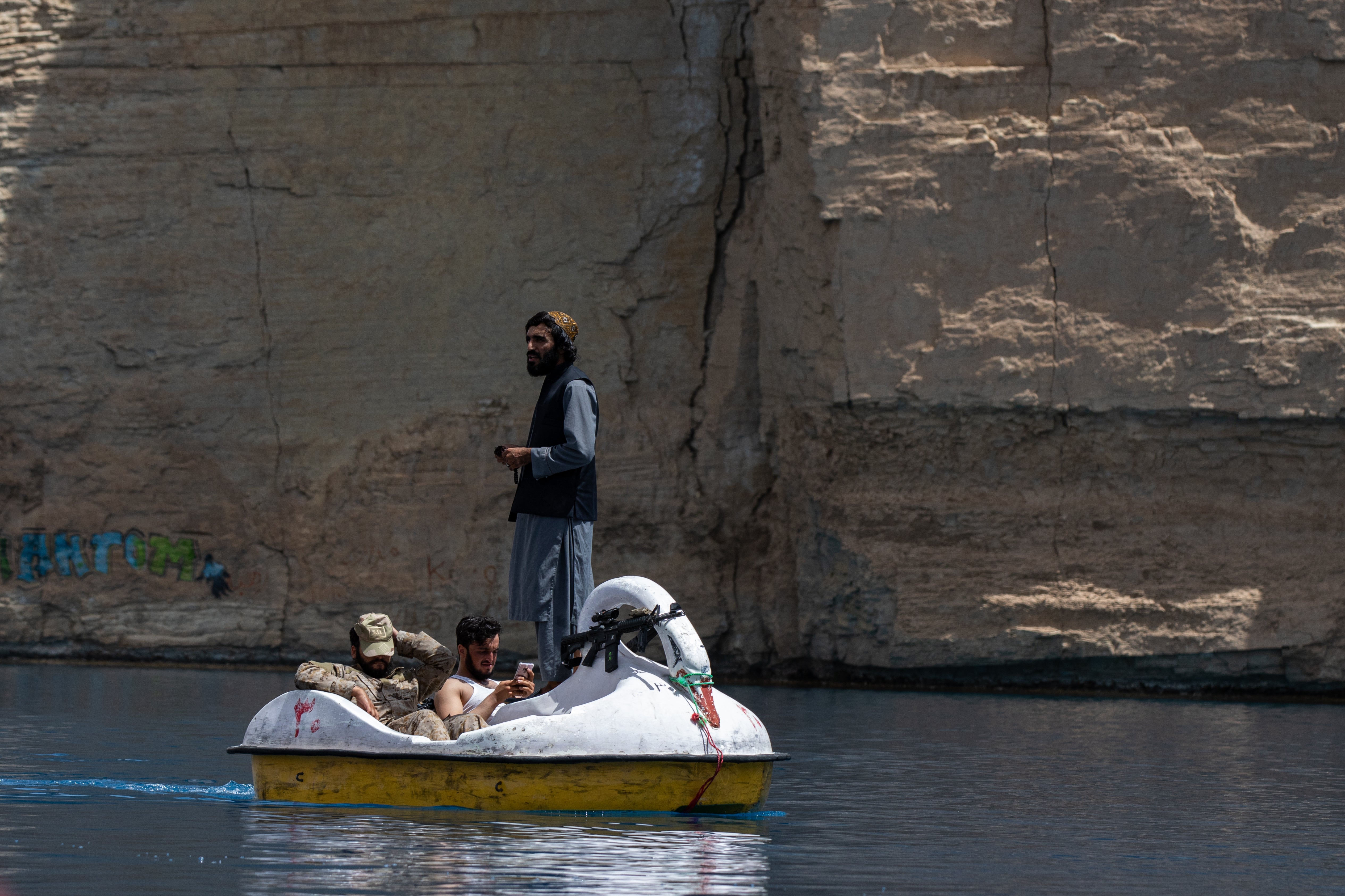 Taliban members paddle in a boat as they and Afghan families enjoy a visit to one of the lakes in Band-e Amir National Park