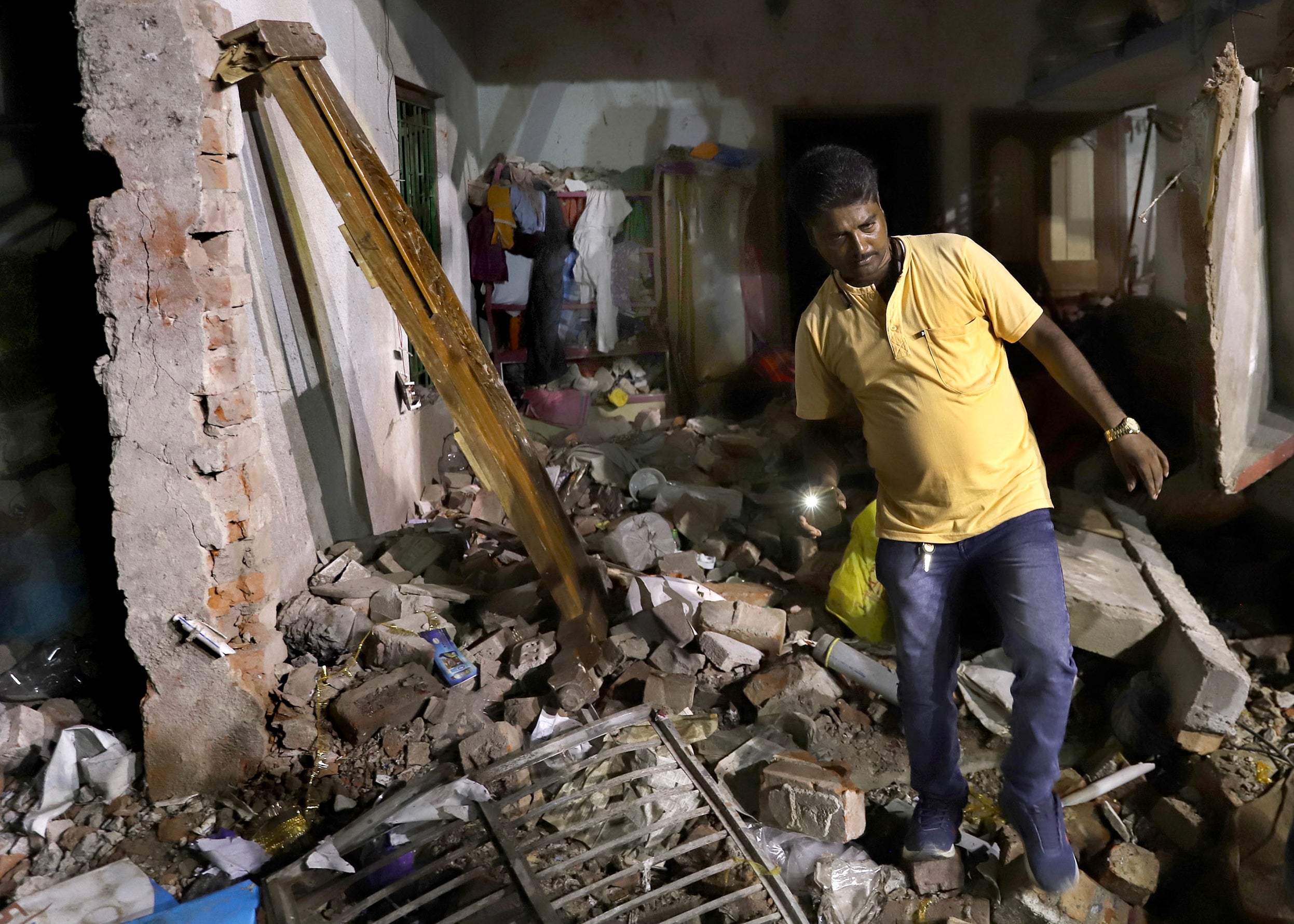 <p>A resident inspects his damaged home after a massive explosion occurred at a firecracker factory in Duttapukur village, east of Kolkata, West Bengal state</p>