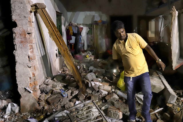 <p>A resident inspects his damaged home after a massive explosion occurred at a firecracker factory in Duttapukur village, east of Kolkata, West Bengal state</p>