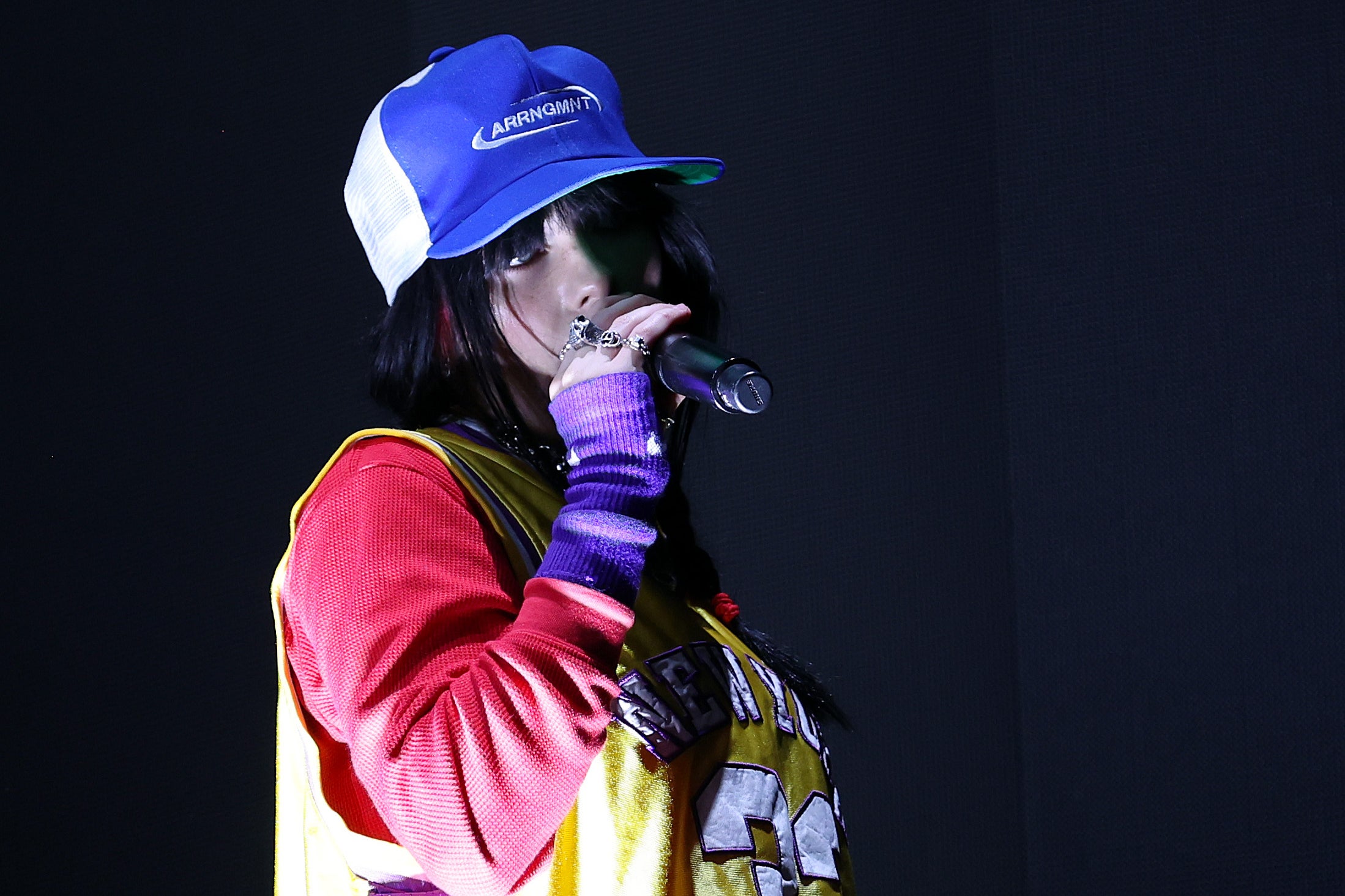 <p>Dressed in bright baseball garb, Billie Eilish performs at this year’s Reading Festival </p>