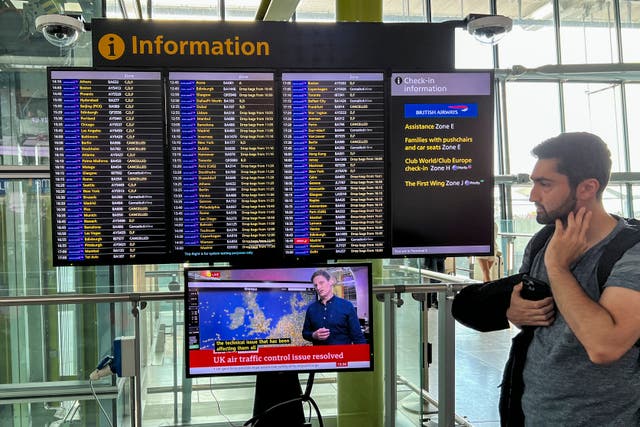 <p>A worried passenger looks at the departures board at London’s Heathrow airport on Monday</p>