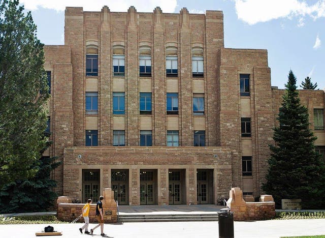 <p>Two people walk on the University of Wyoming campus</p>
