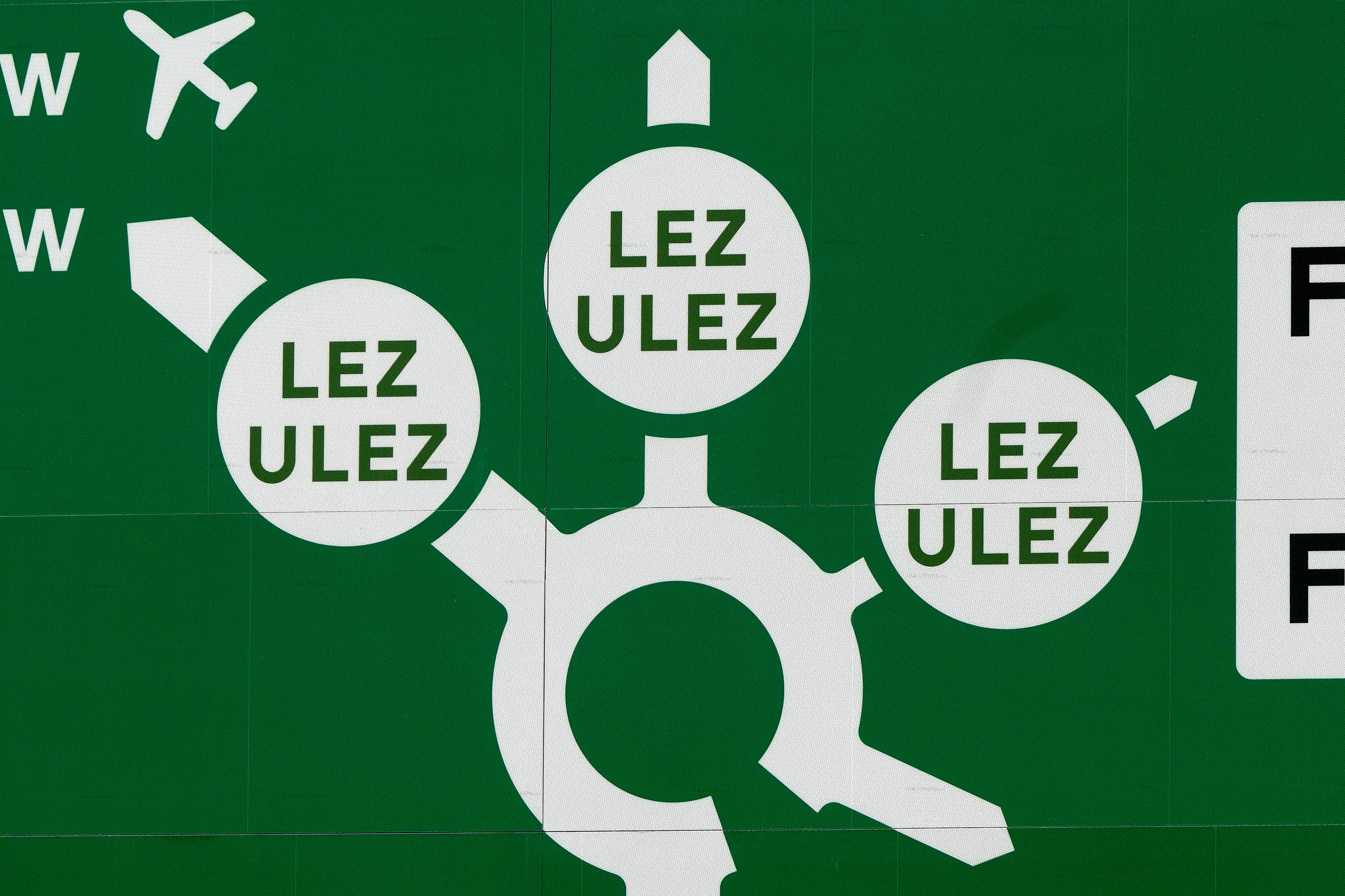 A road sign near a roundabout shows leaving roads into the Ultra Low Emission Zone (ULEZ) in London