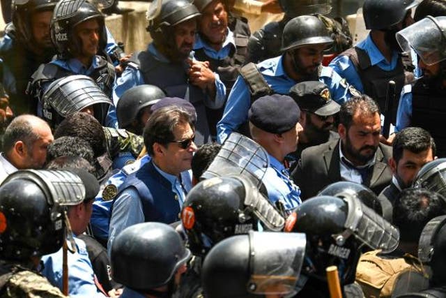 <p>Policemen escort Pakistan’s former prime minister Imran Khan as he arrives at the high court in Islamabad on 12 May 2023</p>