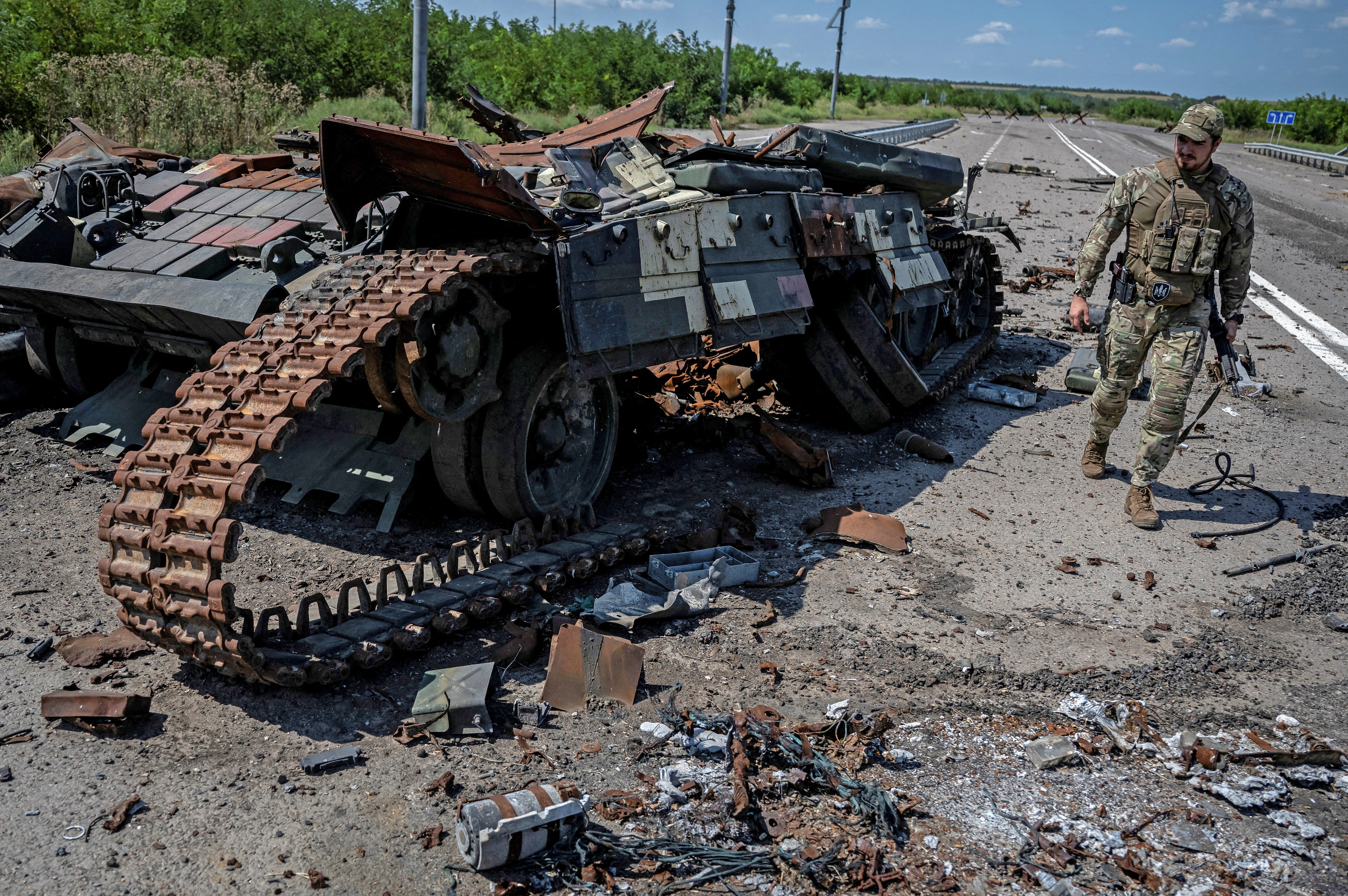 A Ukrainian serviceman walks near a destroyed Ukrainian tank in Robotyne