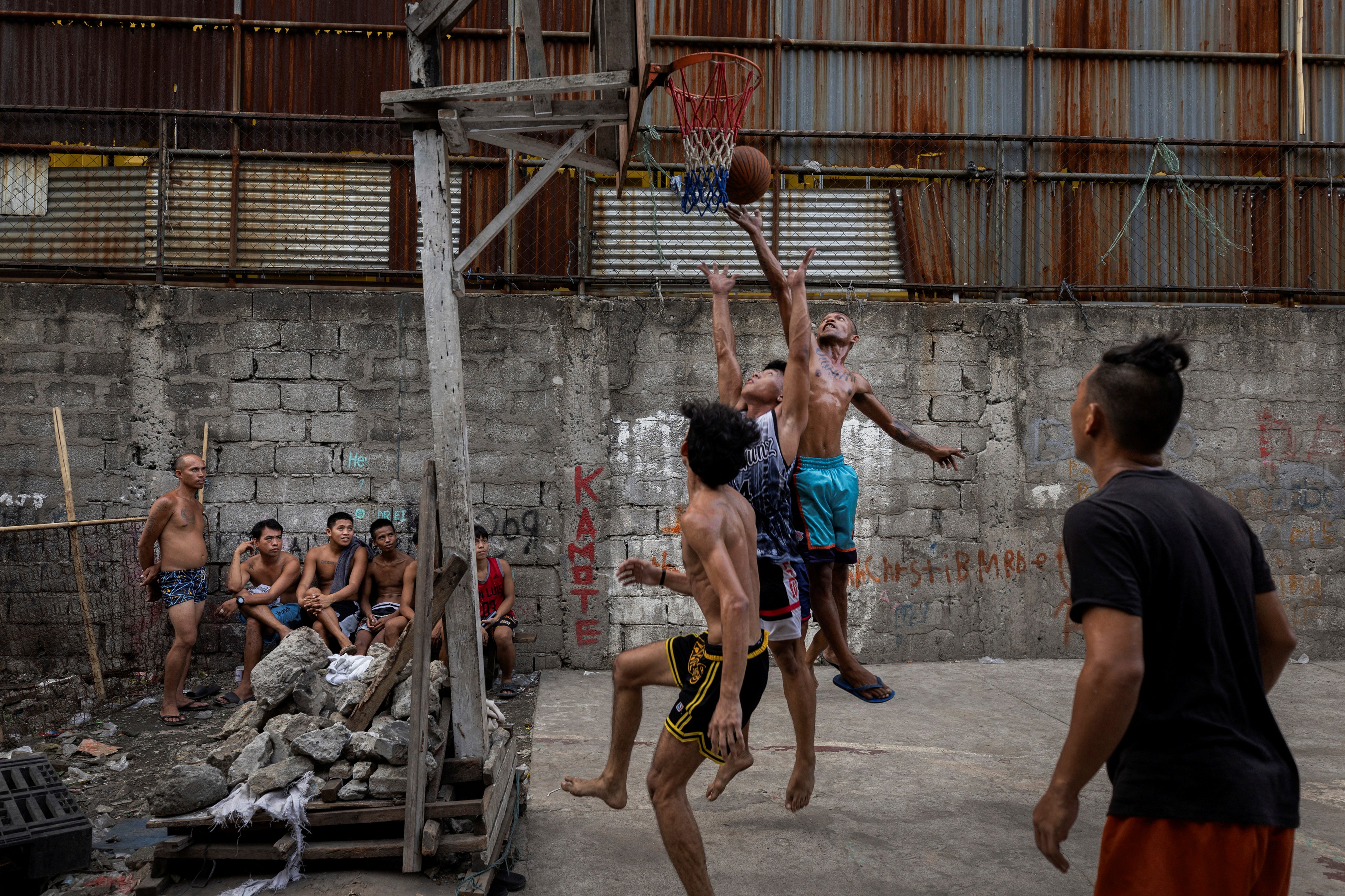 Men play basketball at a community-built court called Baryo Aroma in Tondo, Manila