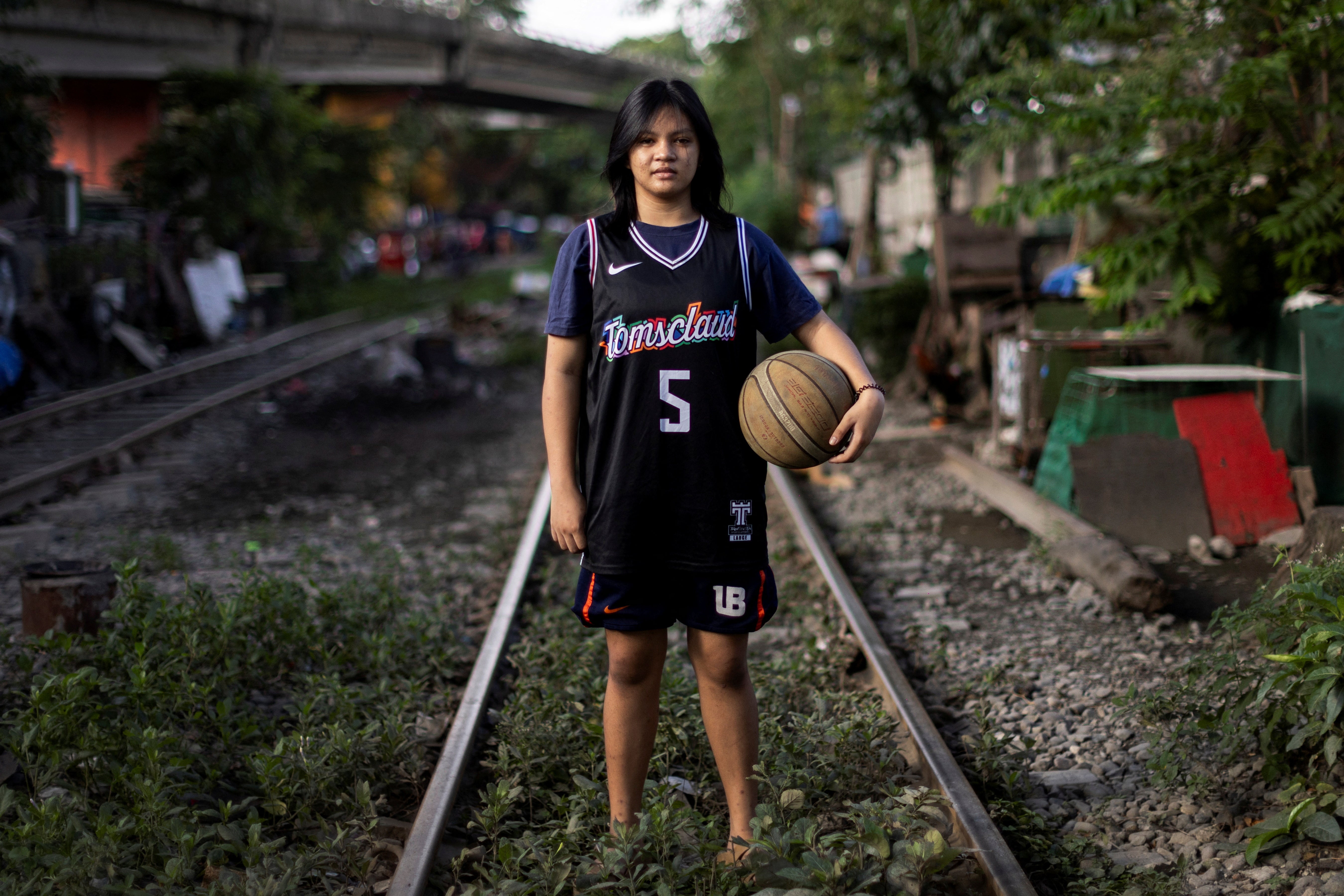 Laurah Agmata, 15, poses for a portrait by the train tracks near where she lives, in Pandacan, Manila