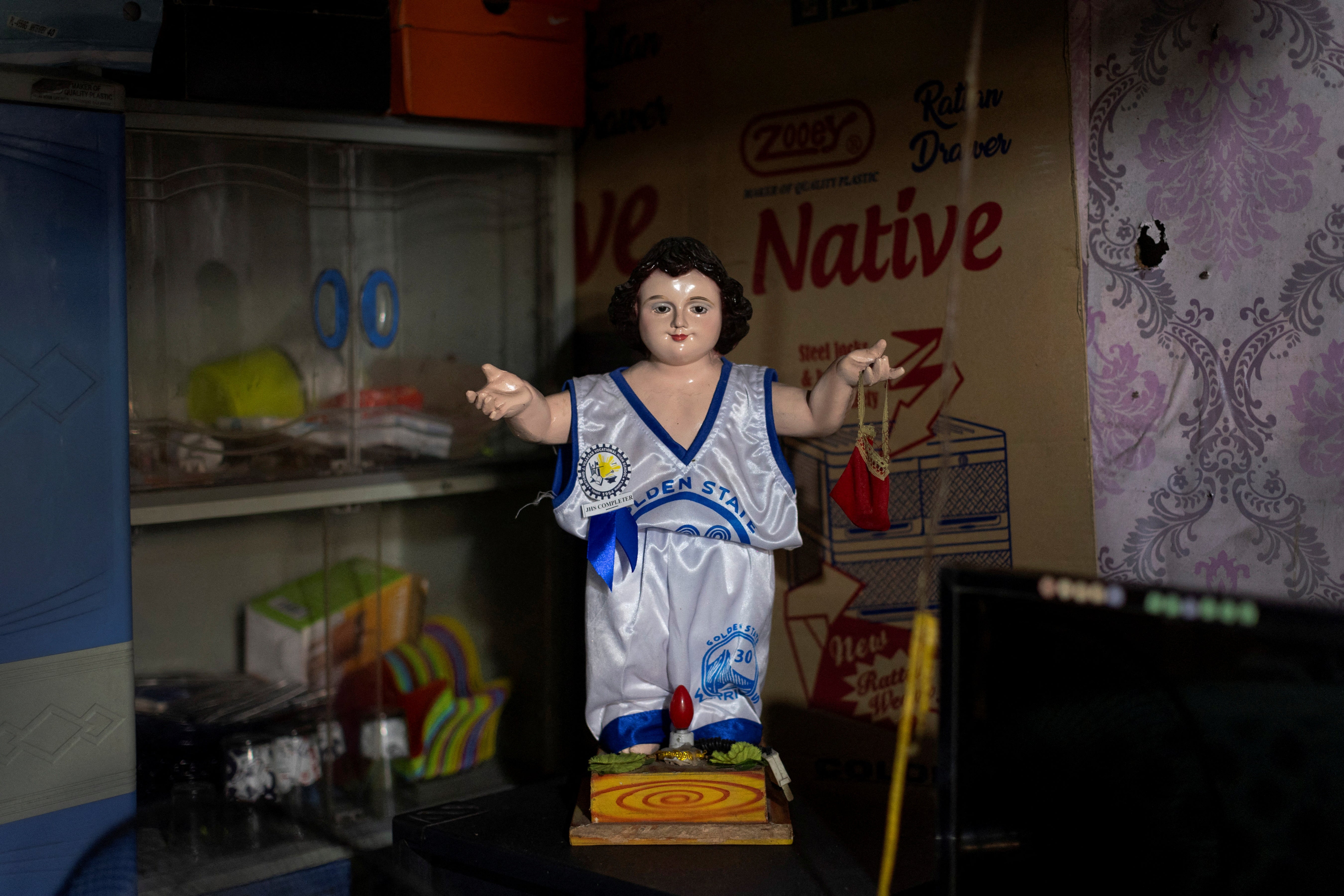 A statue of Jesus Christ dressed in a Golden State Warriors basketball jersey is displayed in the home of 18-year-old basketball enthusiast Jessie Conde in Tondo