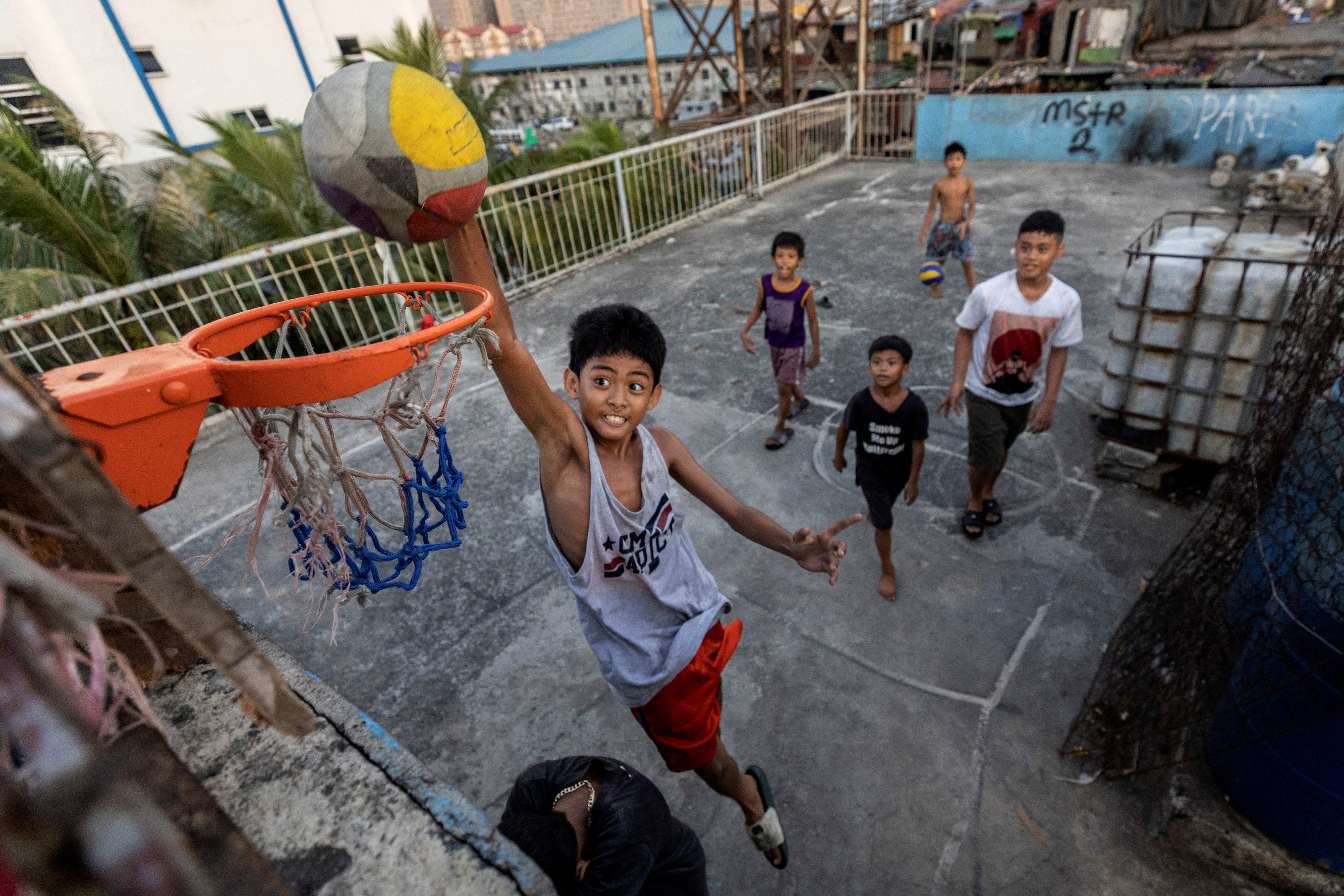Children play basketball on the rooftop of tenement housing in Tondo, Manila