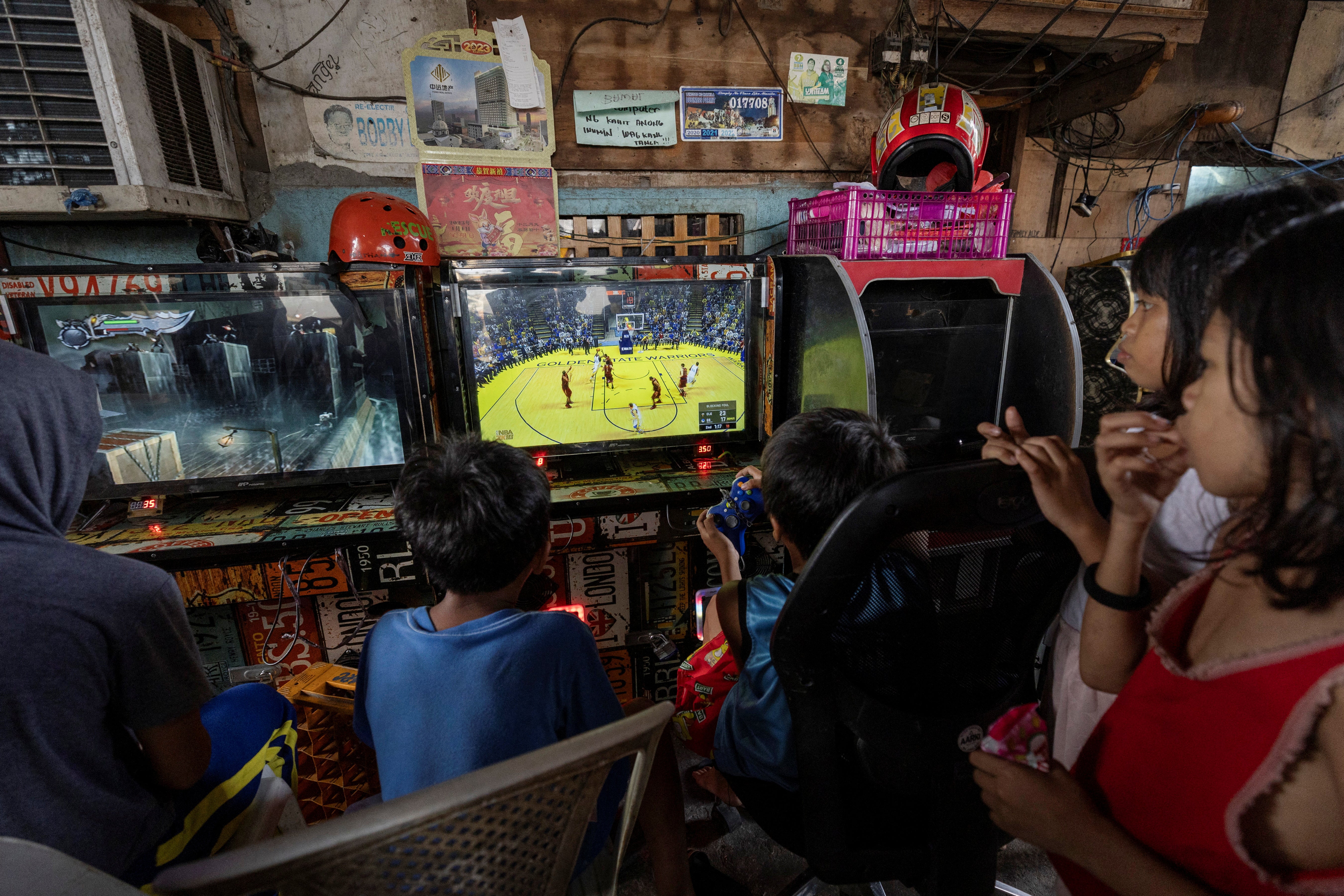 Children play ‘NBA 2K’, a basketball video game, at an internet vending machine known in the Philippines as a pisonet, in Tondo, Manila