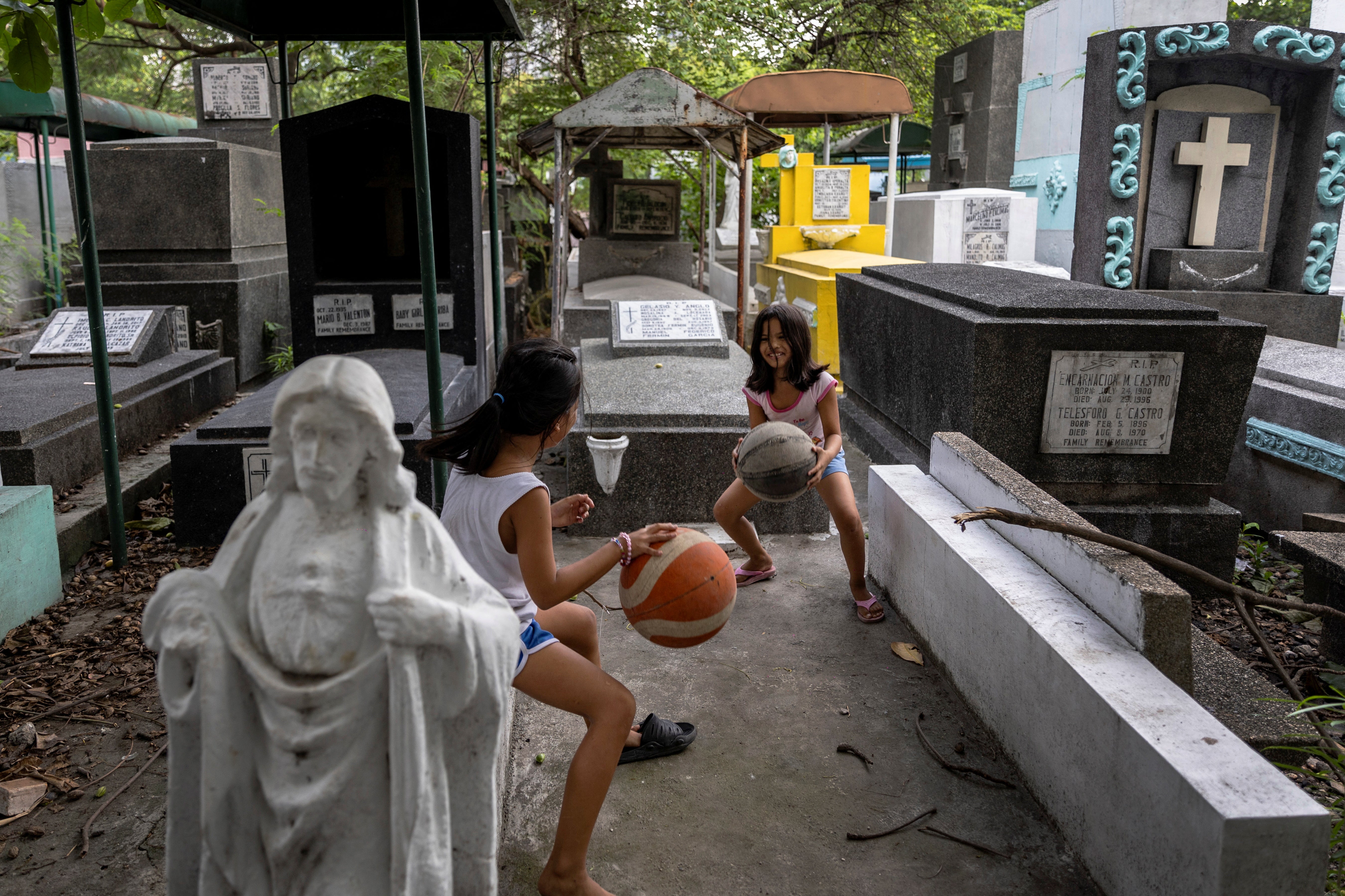 Girls practise dribbling basketballs at Manila South Cemetery in Makati, Manila