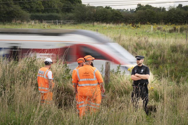 <p>Police and railway workers near the scene in Balderton, near Newark-on-Trent (Danny Lawson/PA)</p>