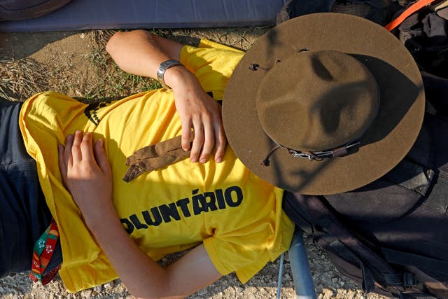 <p>A volunteer takes a nap before the Holy Mass for World Youth Day (WYD) at Parque Tejo on August 5, 2023 in Lisbon, Portugal</p>