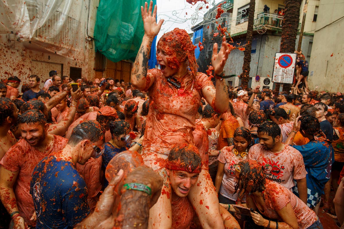 Revellers play in tomato pulp during annual food fight festival La Tomatina in Spain