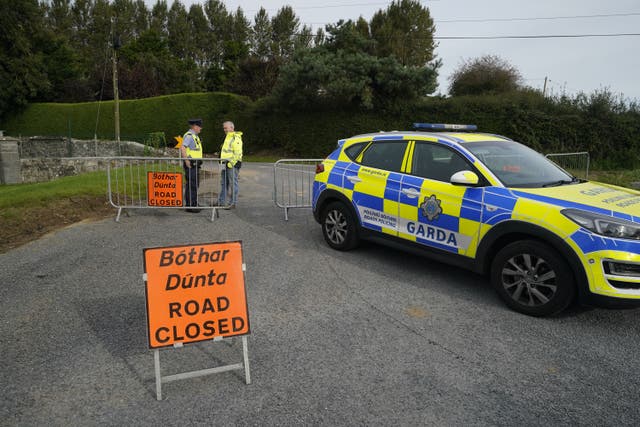 Garda close the road where a man, woman and infant boy have been killed in a road crash in Co Tipperary (Niall Carson/PA)
