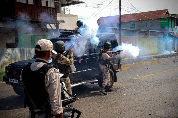 Security personnel fire tear gas shells to disperse members of the Lamlai Kendra village volunteers force