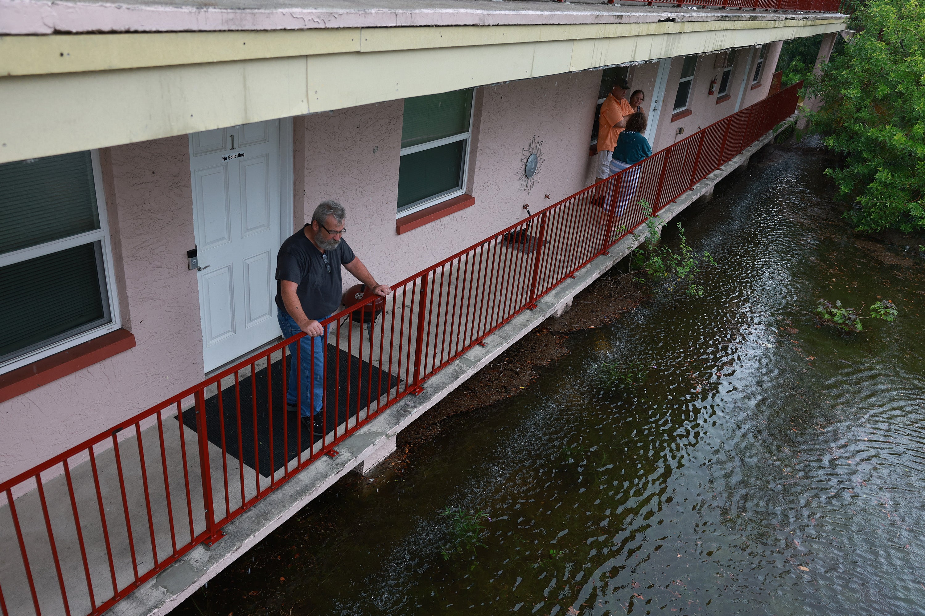 A man looks out at the flood waters from Hurricane Idalia surrounding his apartment complex in Tarpon Springs