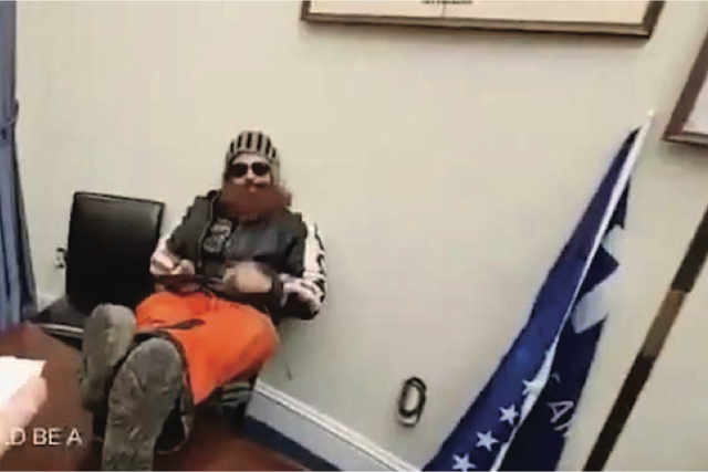 <p>Brandon Fellows, a January 6 rioter, pictured sitting in a Democratic senator’s chair during the Capitol attack</p>
