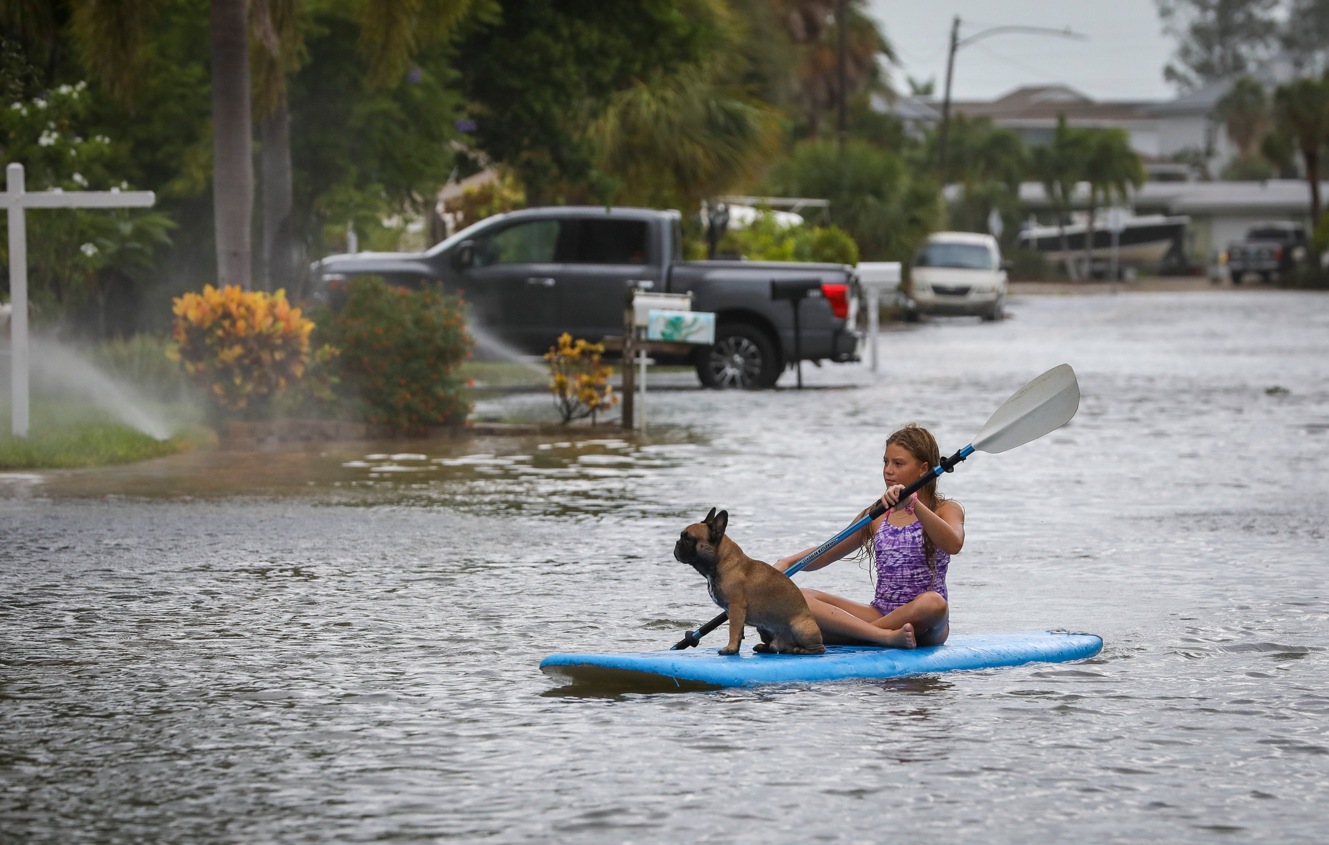 Lily Gumos, 11, of St. Pete Beach, Florida kayaks with her French bulldog along Blind Pass Road and 86th Avenue