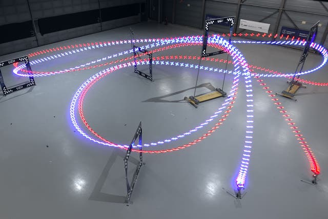 An AI drone (in blue) beat three world-champion drone racers (UZH/Leonard Bauersfeld/PA)