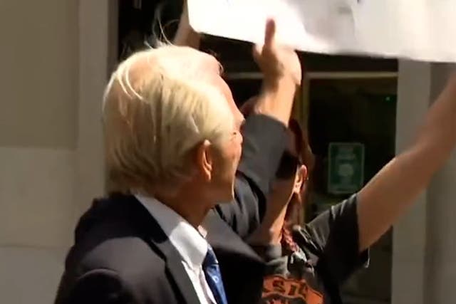<p>Former Trump advisor Peter Navarro attempts to snatch a ‘Trump lost’ sign from protester</p>