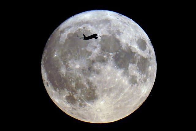 A plane passes the super blue moon over London (Victoria Jones/PA)