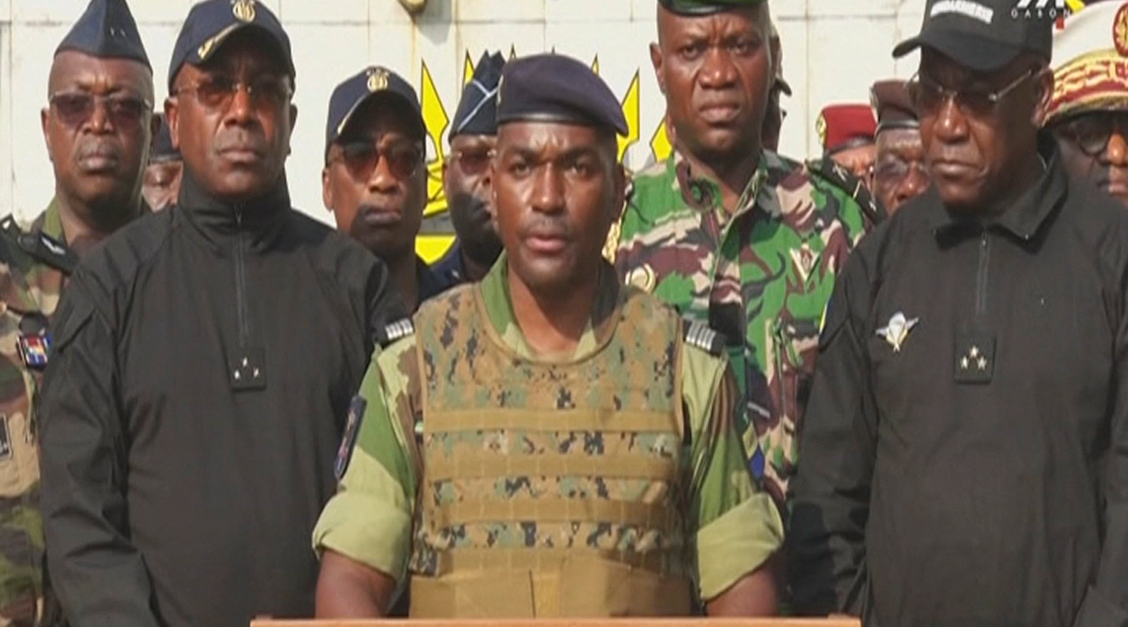 Colonel Ulrich Manfoumbi Manfoumbi (centre), spokesperson of the Committee for the Transition and Restoration of Institutions (CTRI), reading a statement on television