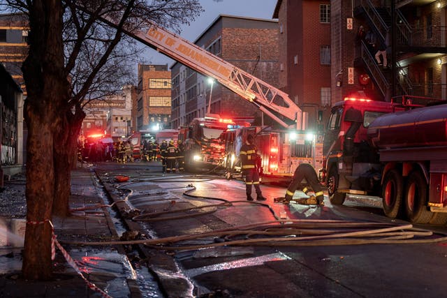 <p>Firefighters work at the scene of a deadly blaze in the early hours of the morning, in Johannesburg, South Africa</p>